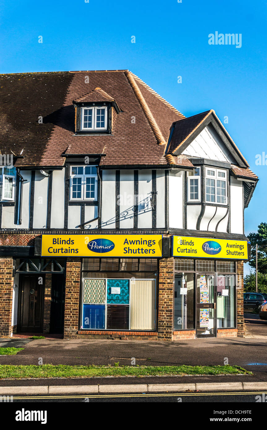 Tende/tendaggi/tende tapparelle/shop, con appartamenti sopra, sul villaggio di Banstead High Street, su di una tranquilla domenica mattina nel Surrey, Inghilterra, Regno Unito. Foto Stock