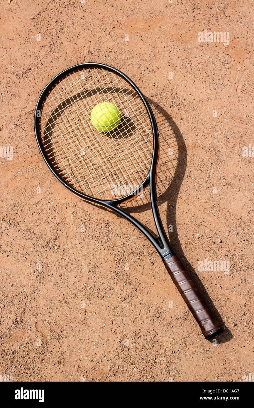 Racchetta da Tennis e sfera gialla su una corte rossa Foto Stock