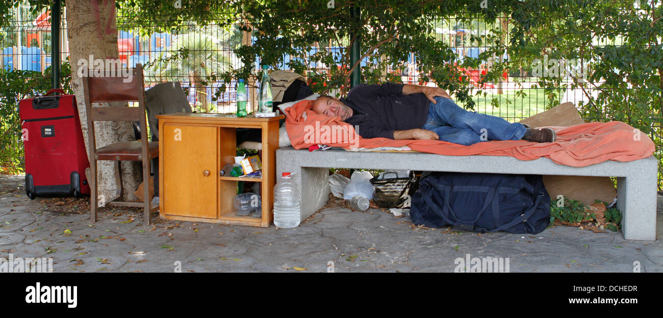 Un senzatetto è visto sul banco di lavoro dove vive con tutti i suoi beni a Palma, nell'isola spagnola di Maiorca Foto Stock