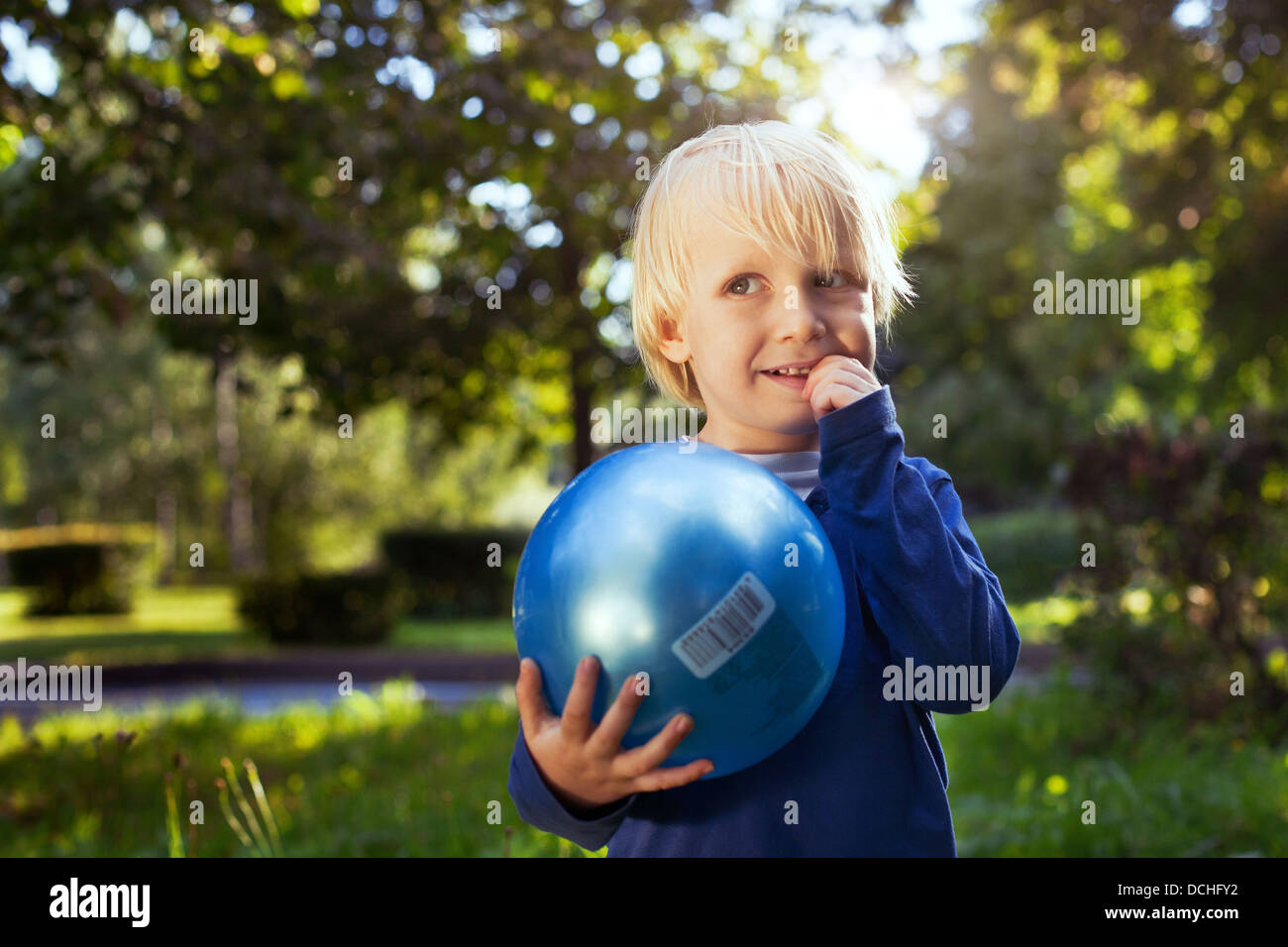 Poco carino ragazzo con la palla cercando Foto Stock