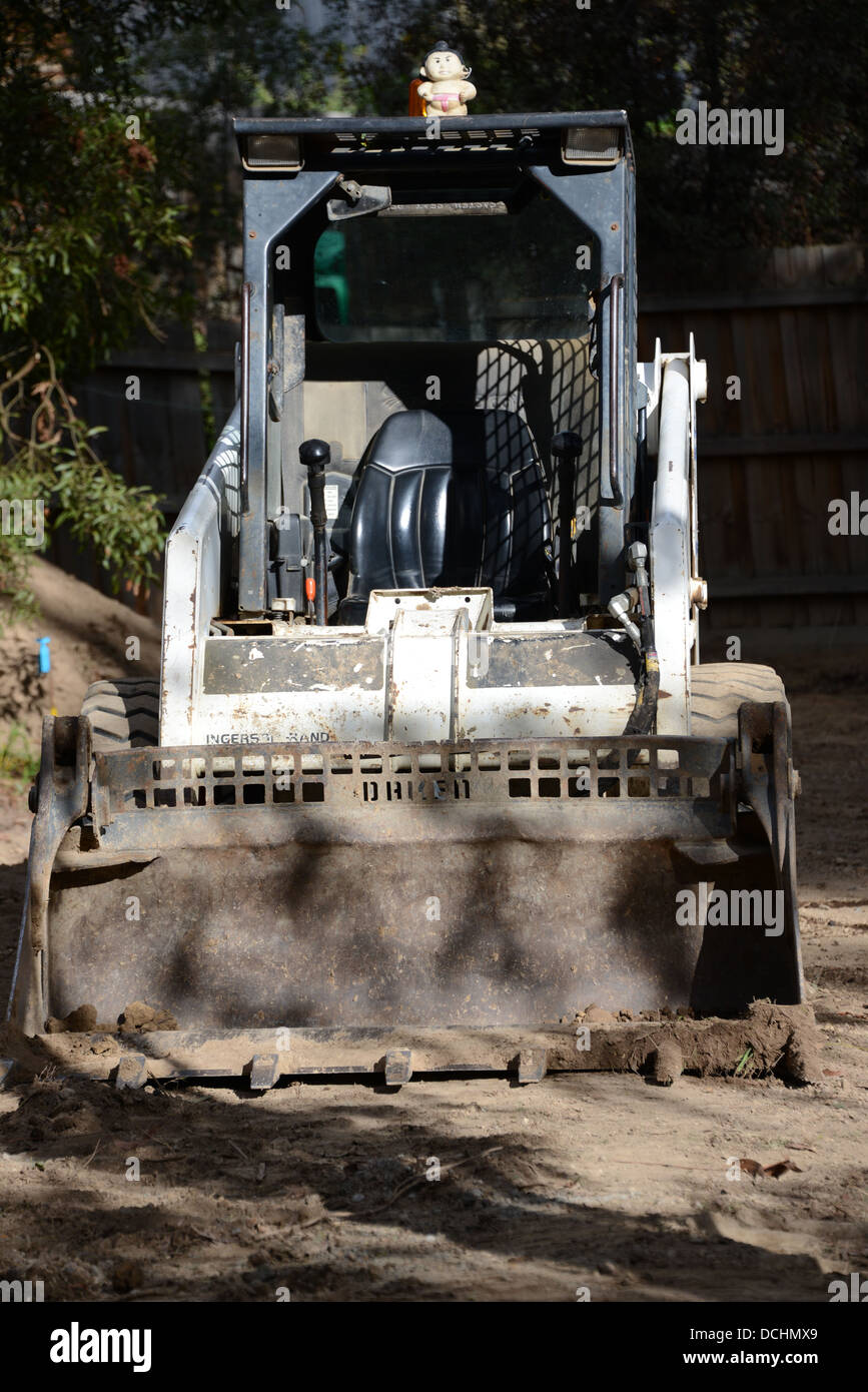 Il trattore bob cat digger su strada sterrata Foto Stock