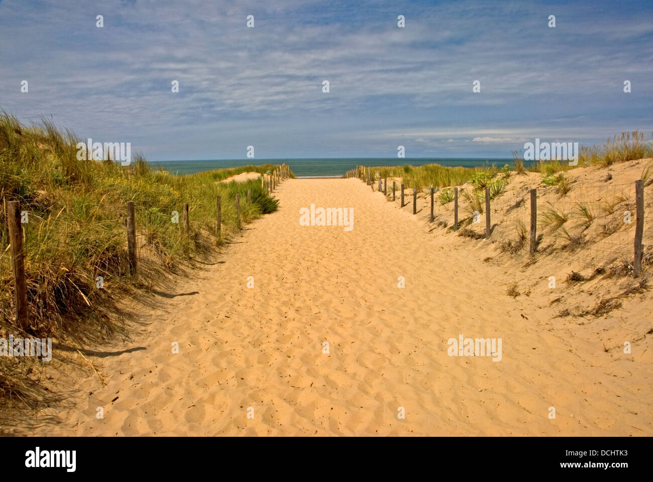 Ampia di sabbia set di percorso tra le recinzioni conduce verso la spiaggia e l'oceano atlantico. Foto Stock