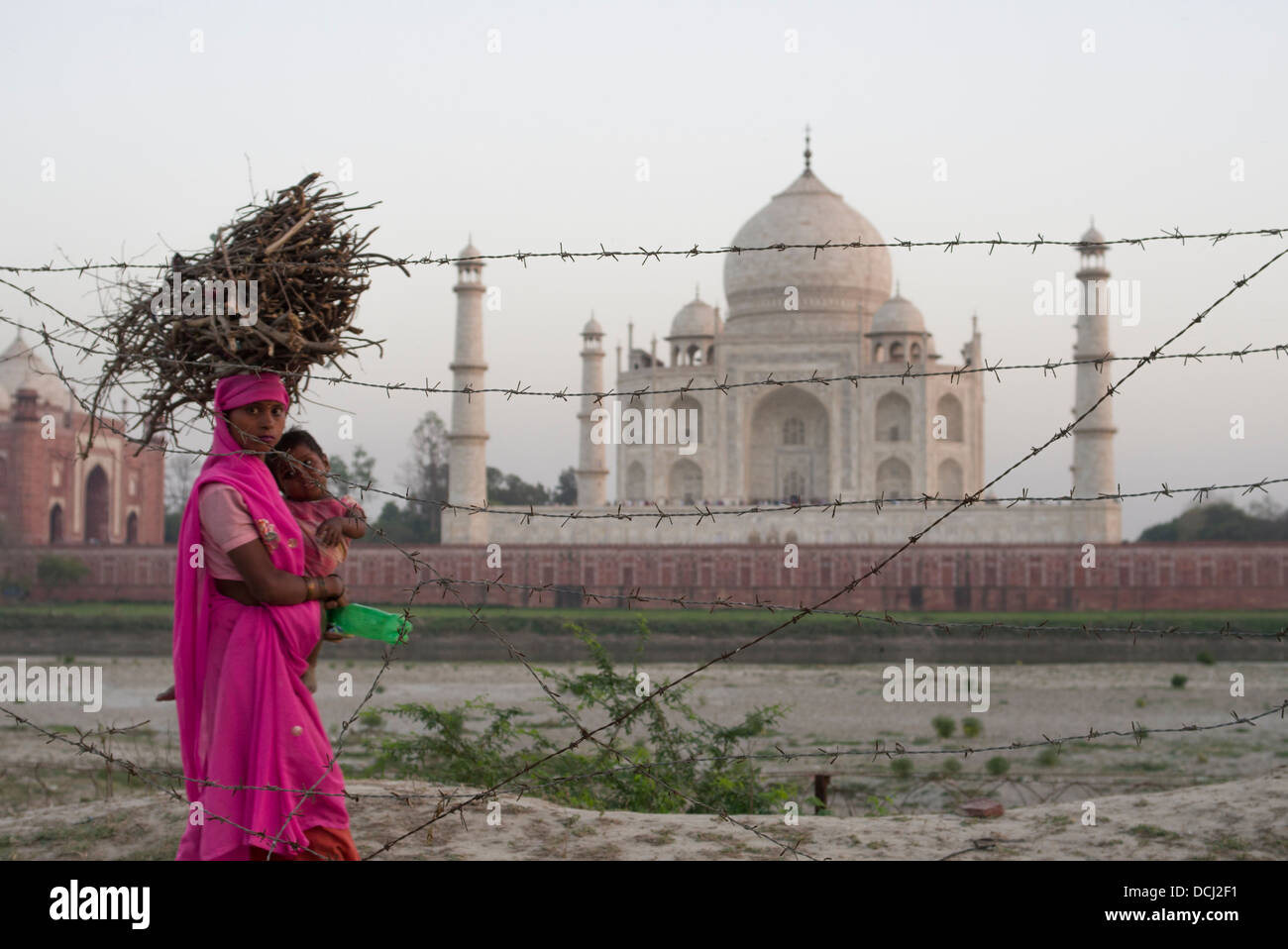 Donna e bambino il filo spinato e il Taj Mahal bianco mausoleo di marmo - Agra, India un Sito Patrimonio Mondiale dell'UNESCO Foto Stock