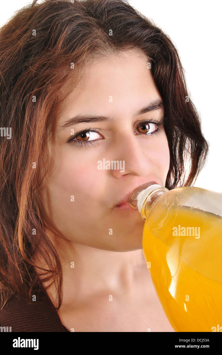 Una giovane donna beve succo di frutta da una bottiglia Foto Stock