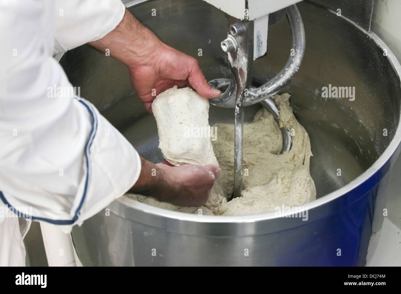 Concetto di cottura - Mani di baker come egli ispeziona la pasta Foto Stock