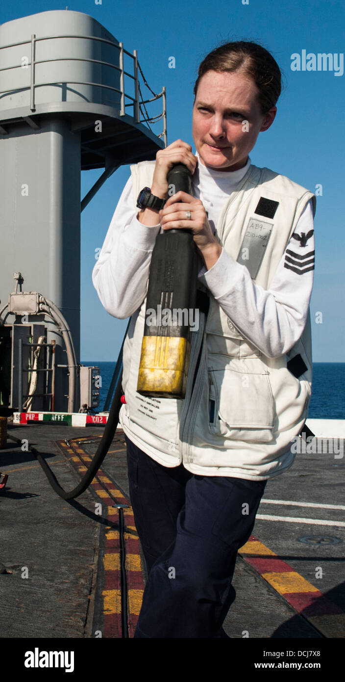 Aviation Electronics tecnico di prima classe Zayas Kaitlin, da Taneytown, Md., assegnati alla lotta contro leoni neri di Strike Fighter Squadron (VFA) 31, tira un cavo di alimentazione di un velivolo a bordo della portaerei USS George H.W. Bussola (CVN 77). George H. Foto Stock