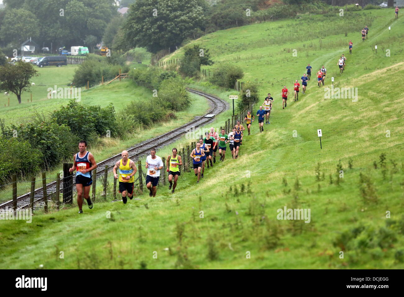 Tywyn, Wales, Regno Unito, Sabato, 17 agosto 2013 nell'immagine: centinaia di guide di scorrimento da un treno via vicino Tywyn, Galles. Re: gara il treno è un annuale cross country in esecuzione evento che avviene in Tywyn, metà del Galles. La gara è organizzata da Tywyn Rotary Club, e attrae corridori provenienti da tutto il mondo. Nel main event, corridori competere per battere un treno a vapore su conserve Talyllyn Railway su una distanza di 14 miglia (23 km). La manifestazione è stata l'idea di dentista locale, Godfrey Worsey, e fu eseguita per la prima volta nel 1984 con circa 48 guide. © D Legakis/Alamy Live News Foto Stock