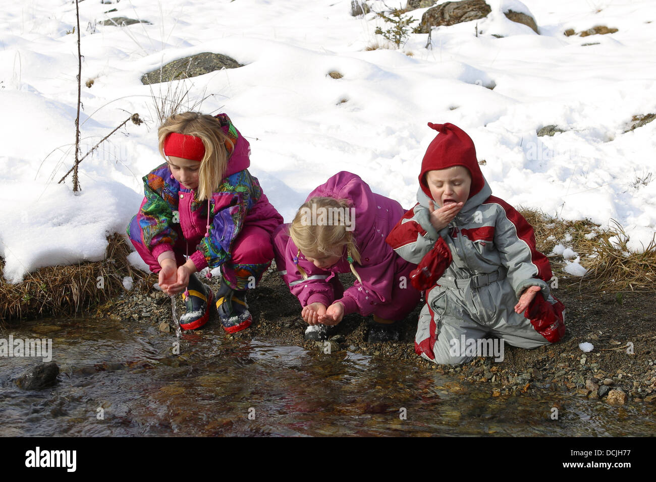 Sono i bambini Cristallo di bere acqua chiara di montagna da brook, Kinder trinken kristallklares Gebirgswasser aus Bach Foto Stock