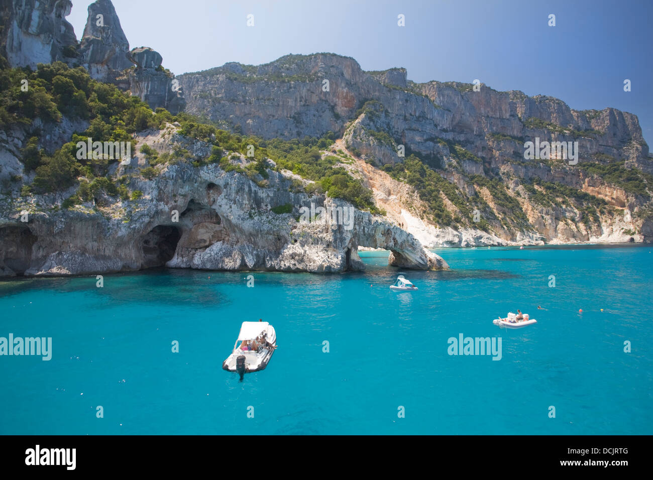 Barche in acque cristalline del Golfo di Orosei, Sardegna, Italia Foto Stock