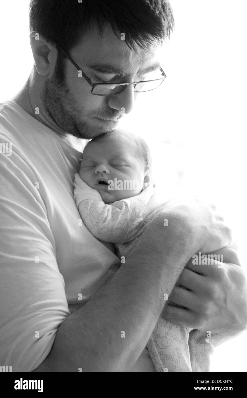 Padre protettivo tenendo la sua nuova nata figlia Foto Stock