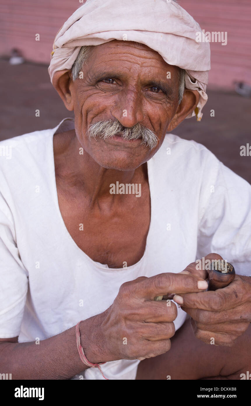 Uomo indiano di tabacco da fumo con tubazione - Jaipur, Rajasthan, India Foto Stock