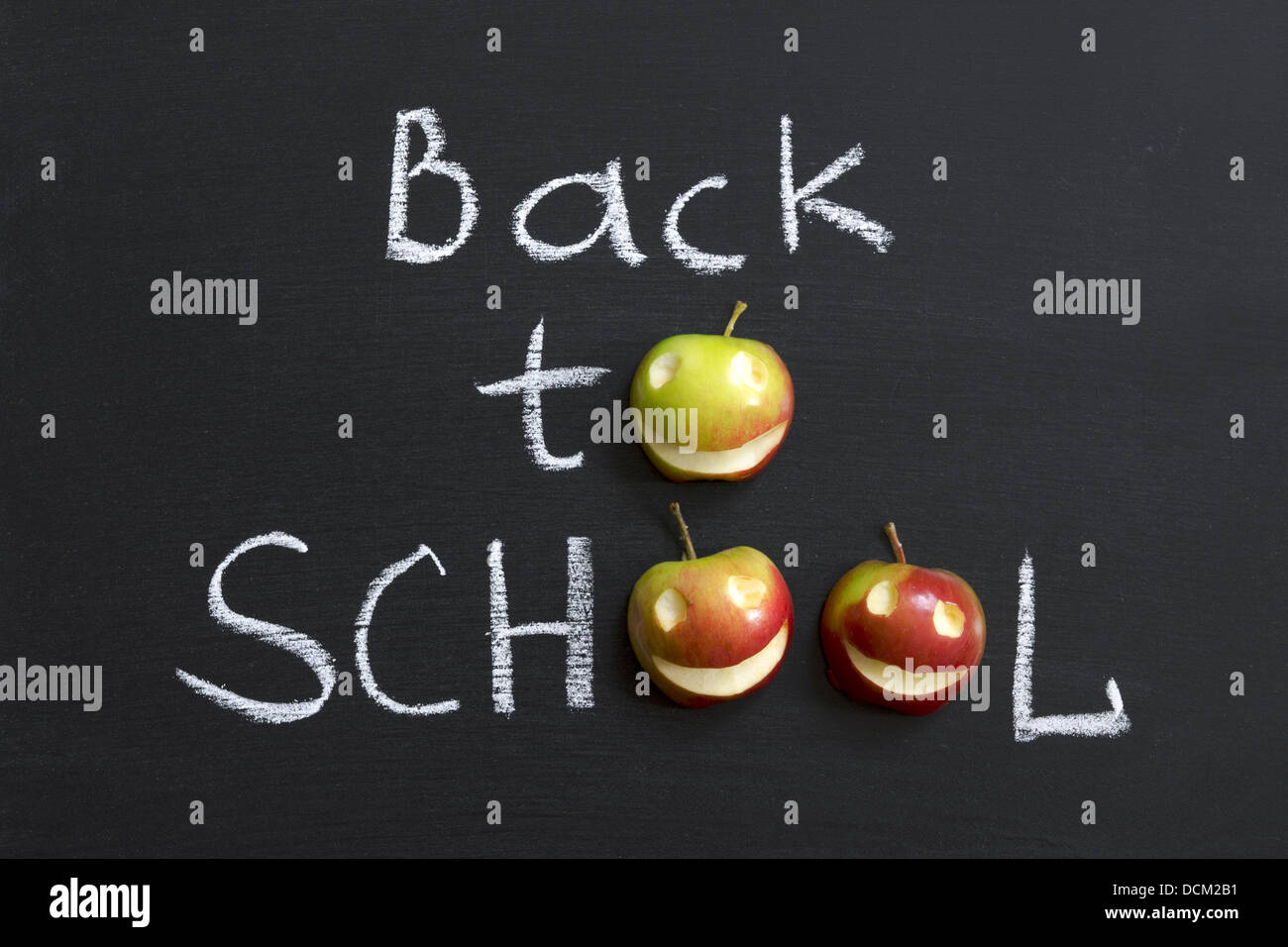 Si torna a scuola la frase con le mele sorridente manoscritta su lavagna Foto Stock