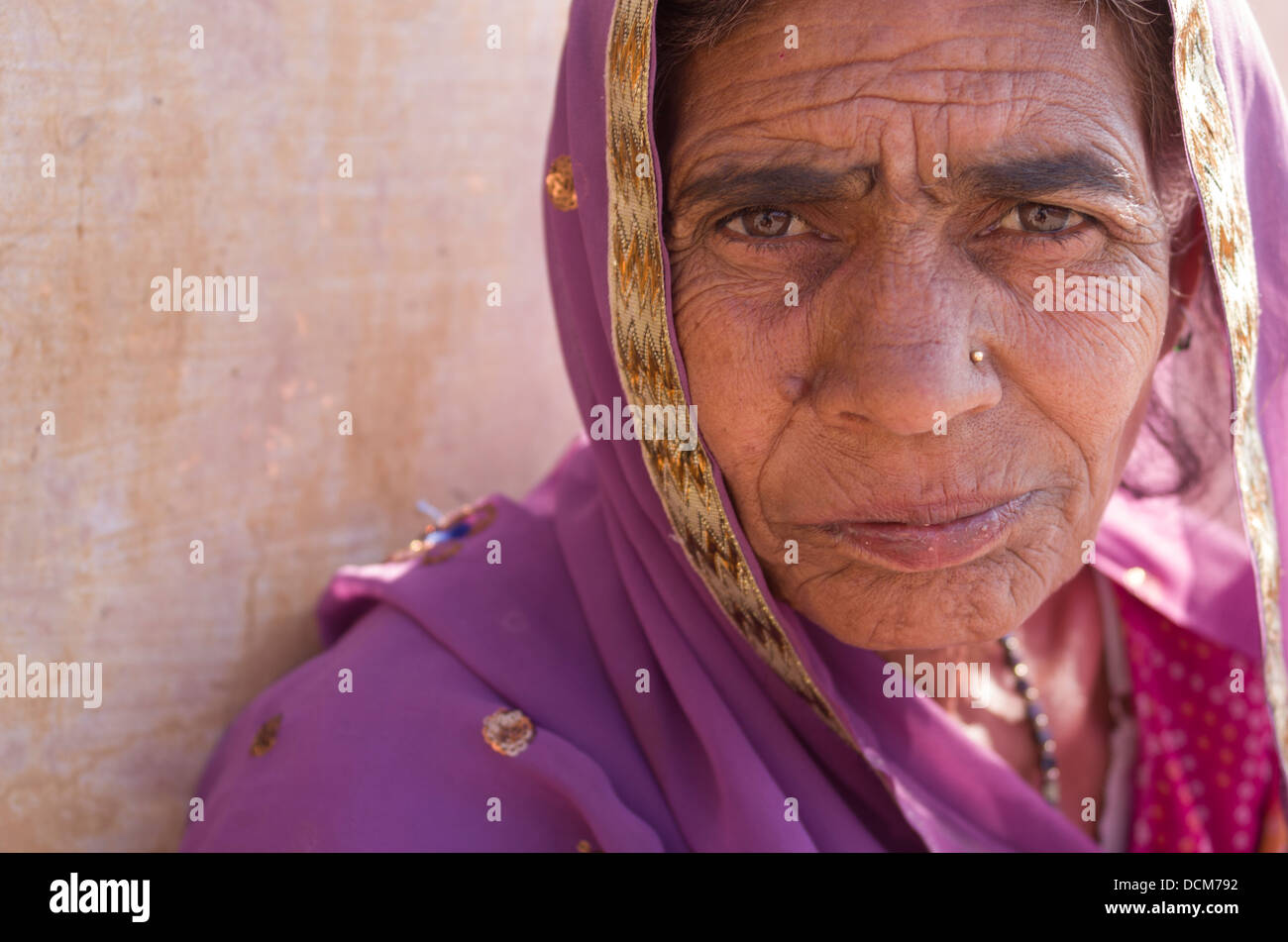 Anziani donna indiana in viola sari all'Amber ( Amer ) Fort / Palace - Jaipur, Rajasthan, India Foto Stock