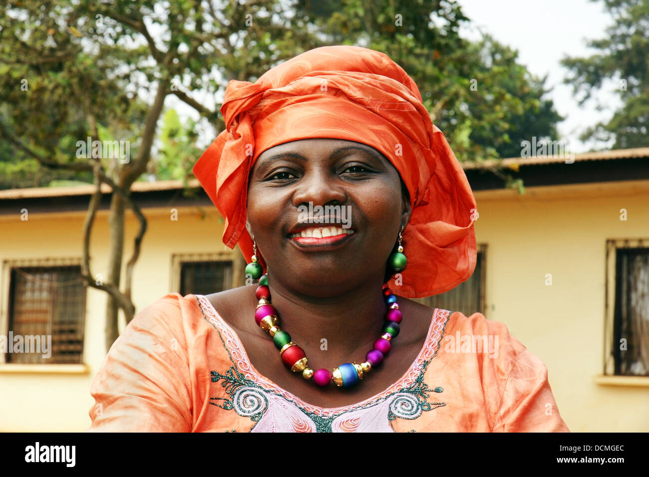 Sorridente donna africana in foulard arancione Foto Stock