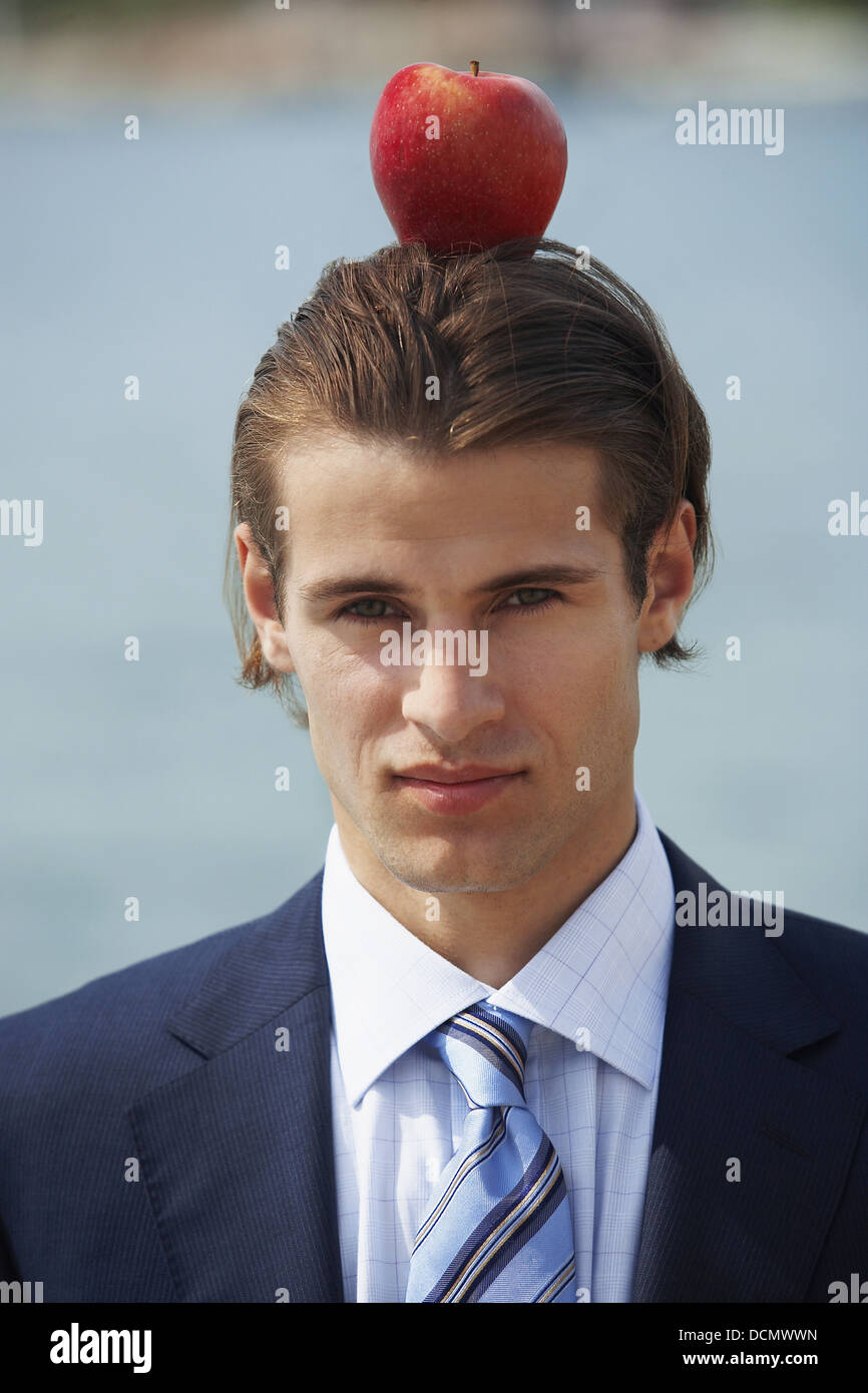 Uomo d affari con Apple bilanciato sulla sua testa Foto Stock