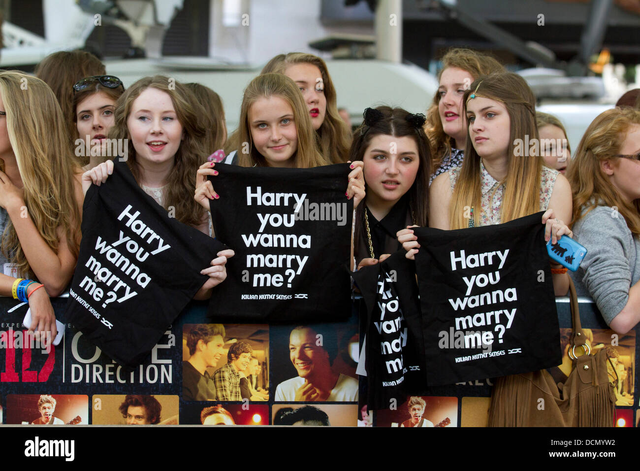 Leicester Square, Londra, Regno Unito. 20 agosto 2013. Tifosi in attesa Camicie stampate di una direzione gli stati Harry stili come migliaia di appassionati si radunano davanti a una direzione premiere mondiale 'Questo è noi' nel quadrato di Leicester Credit: amer ghazzal/Alamy Live News Foto Stock