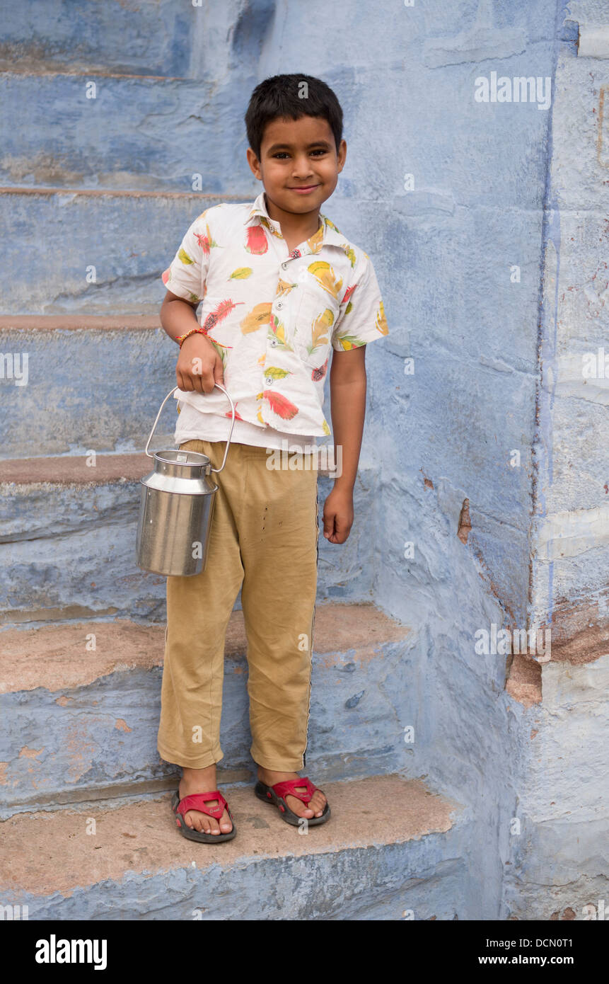 Giovane ragazzo indiano con piccolo Secchio di Latte blu con pareti dipinte di Jodhpur la città blu, Rajashtan, India Foto Stock