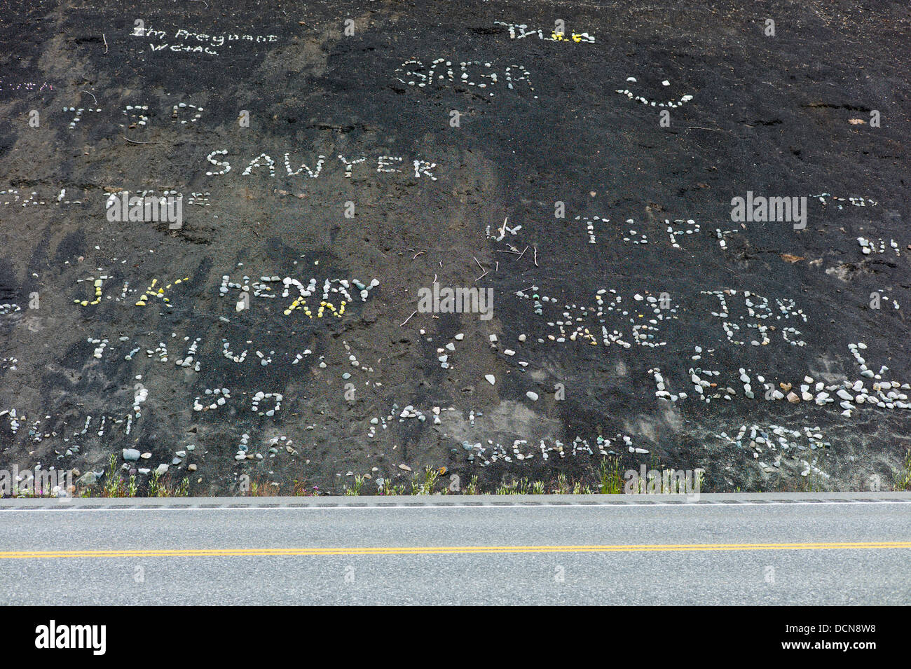 I bambini utilizzano rocce bianche sulla collina di nero per creare i segni e nome, Glenn Highway, Highway 1, Alaska Foto Stock