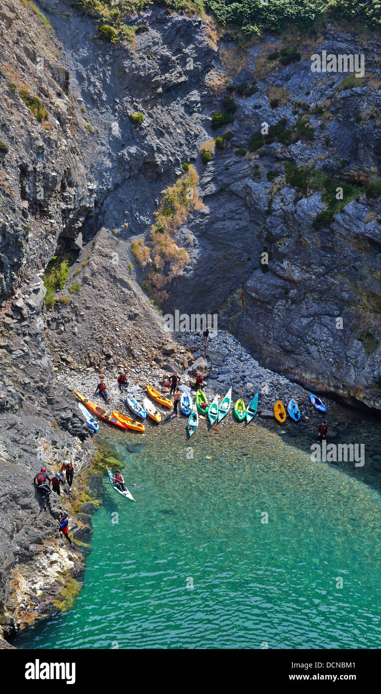 La flottiglia di mare kayakers spiaggiata in una baia a Careg Yspar vicino a Newport Pembrokeshire sulla South Wales coast path Foto Stock