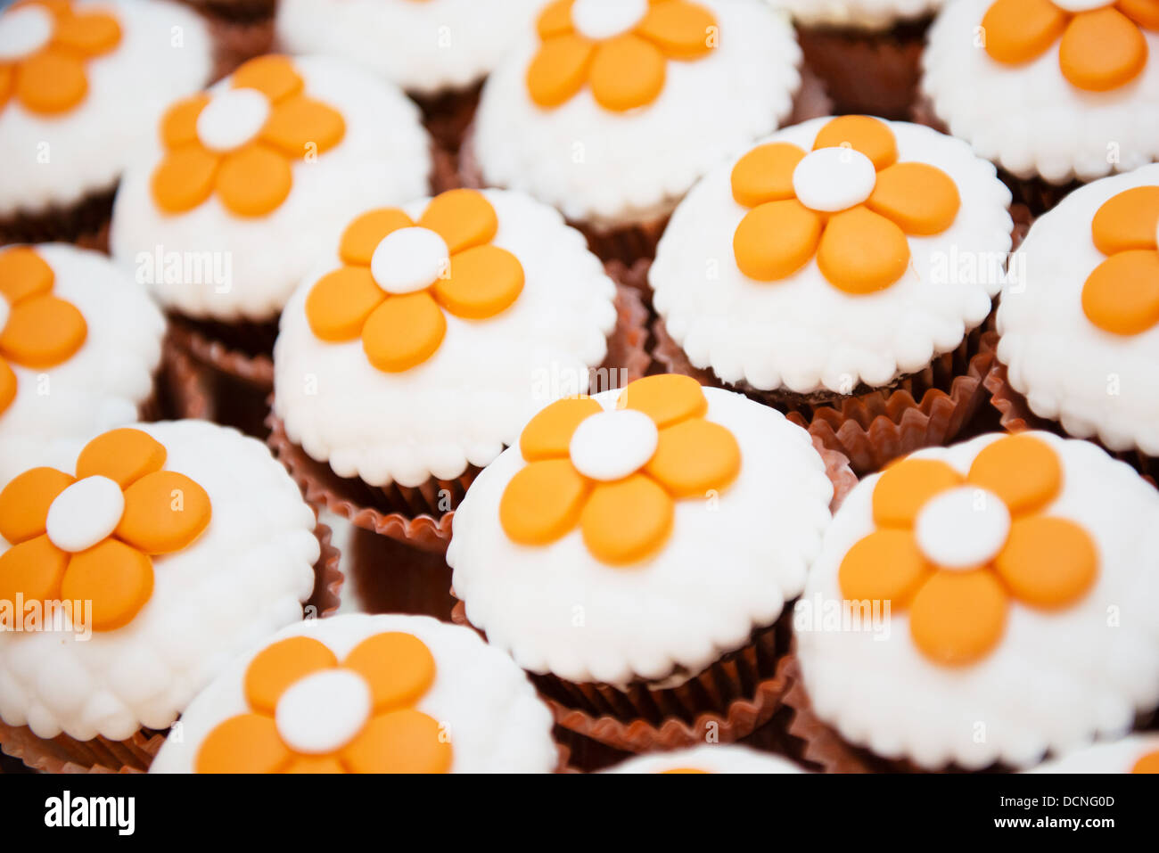 Deliziosi tortini di cioccolato con fiori arancione sulla parte superiore Foto Stock