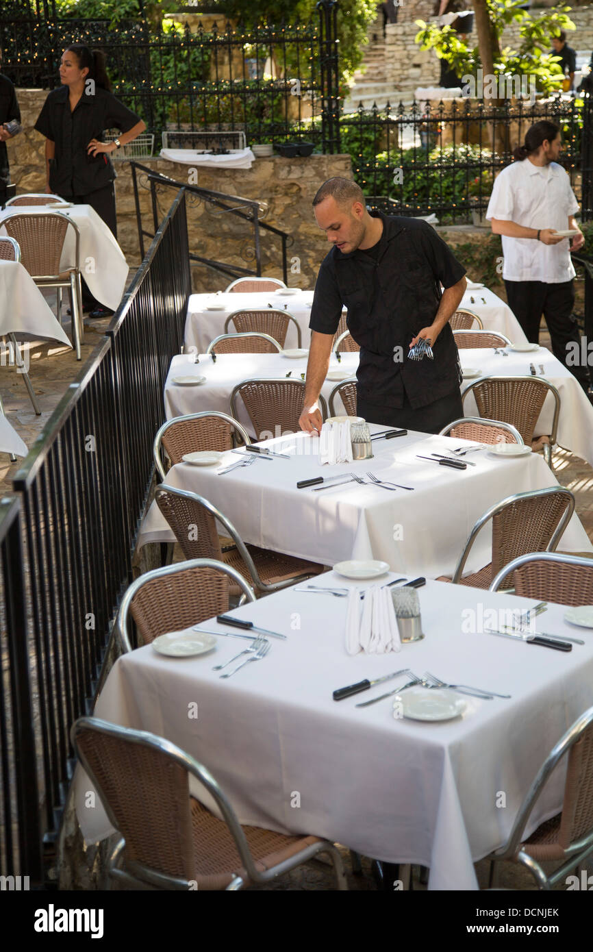 San Antonio, Texas - un cameriere di insiemi di tabelle per la cena in un ristorante sul lungofiume. Foto Stock
