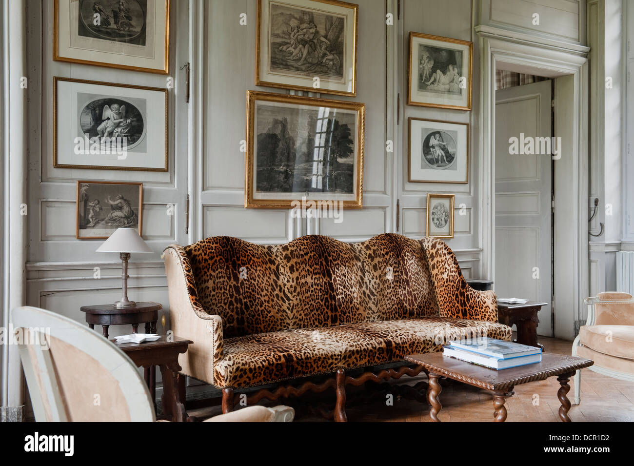 Francese antico divano imbottito in Leopard Tessuto di stampa in soggiorno con pareti in legno pannelli Foto Stock