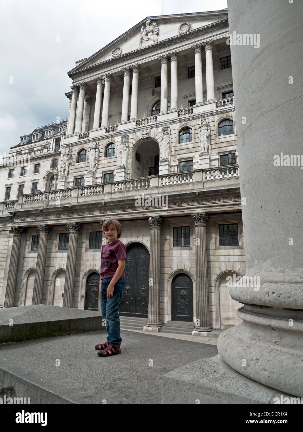 Ragazzo che sta al di fuori di fronte alla Banca di Inghilterra su Threadneedle Street in occasione di una visita alla città di Londra, Inghilterra UK KATHY DEWITT Foto Stock
