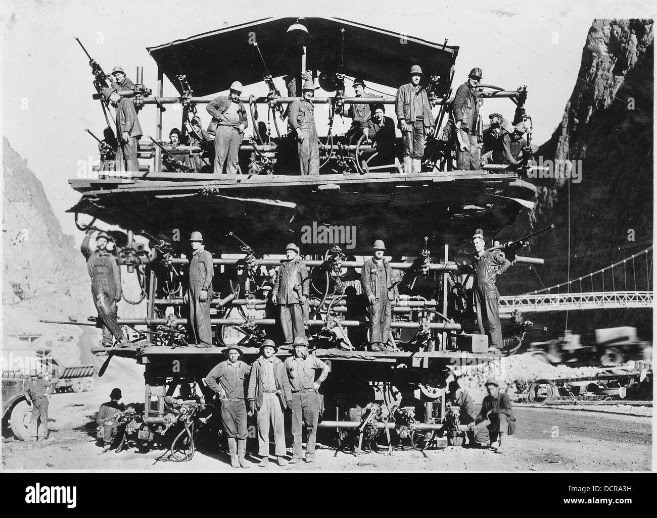 Viene mostrato un carro di perforazione montato su autocarro utilizzato da sei aziende che lavora su tunnel di deviazione. Questo carro è posizionato nella parte superiore dei tunnel, dove esegue operazioni di perforazione essenziali per i progetti di costruzione. Foto Stock