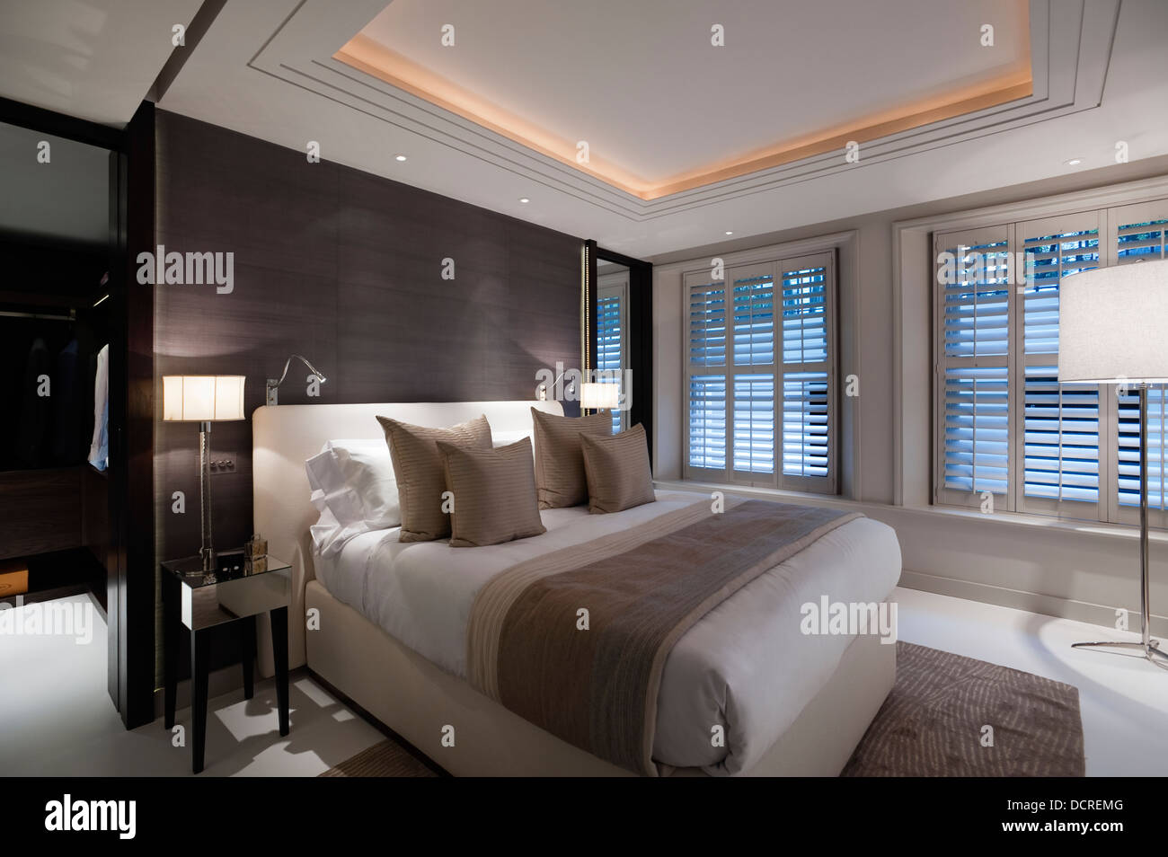 Camera da letto illuminazione nero con pareti rivestite in London city apartment Foto Stock