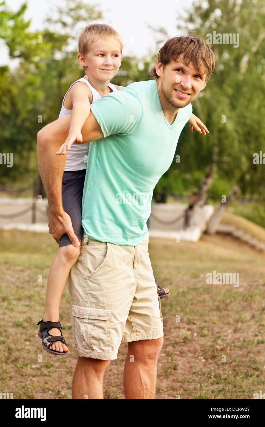 Padre di famiglia uomo e figlio Bambino giocando Outdoor felicità emozione con estate natura sullo sfondo Foto Stock