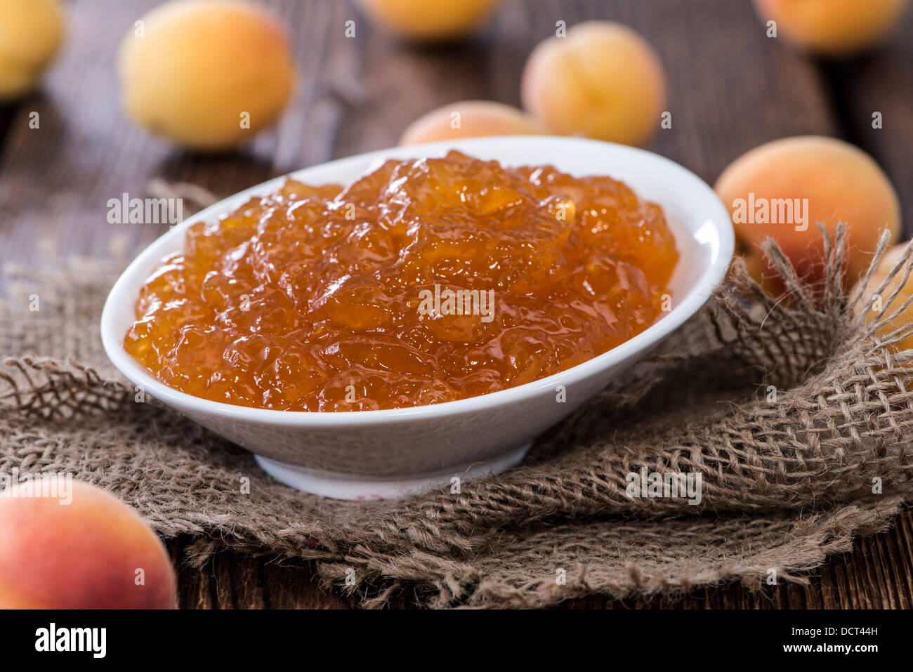 Porzione di marmellata di albicocche su rustico sfondo di legno Foto Stock