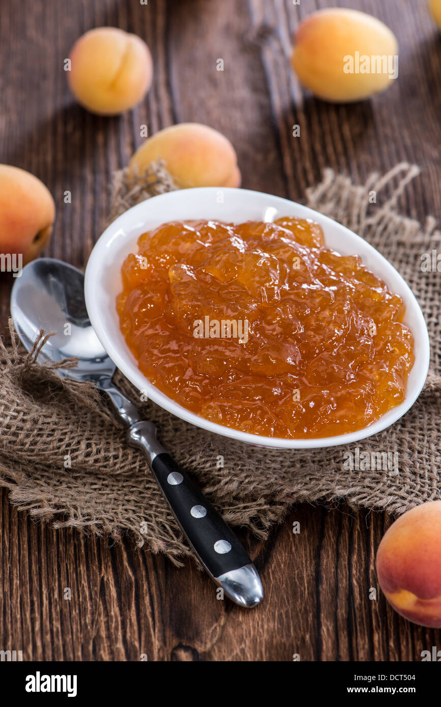 Porzione di marmellata di albicocche su rustico sfondo di legno Foto Stock