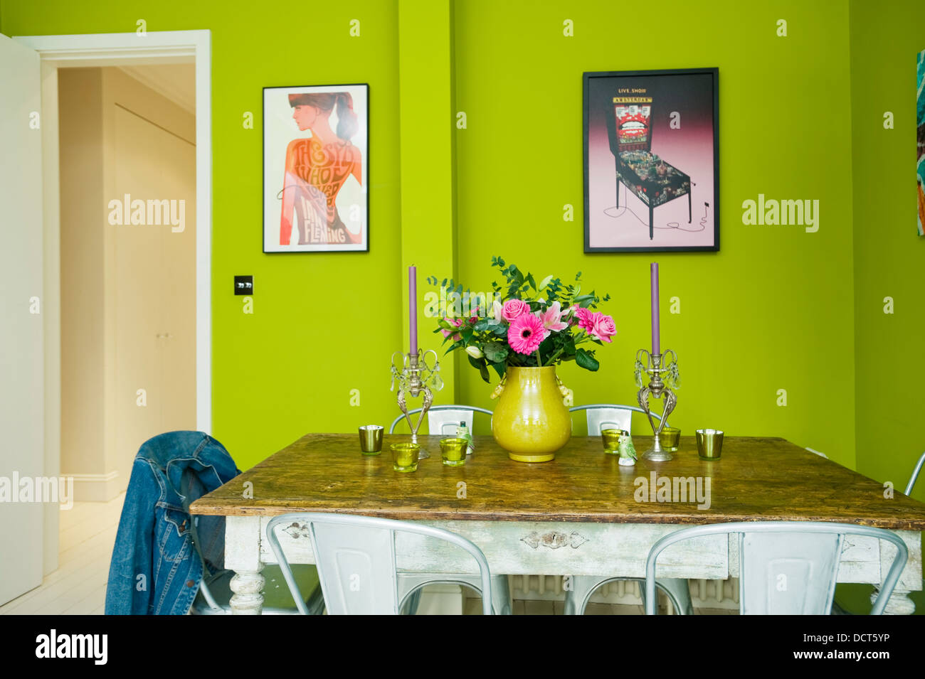 Tavolo in legno da Alfies mercatino di antiquariato con sedie da pranzo dal negozio Conran in cucina con luminose pareti verde Foto Stock