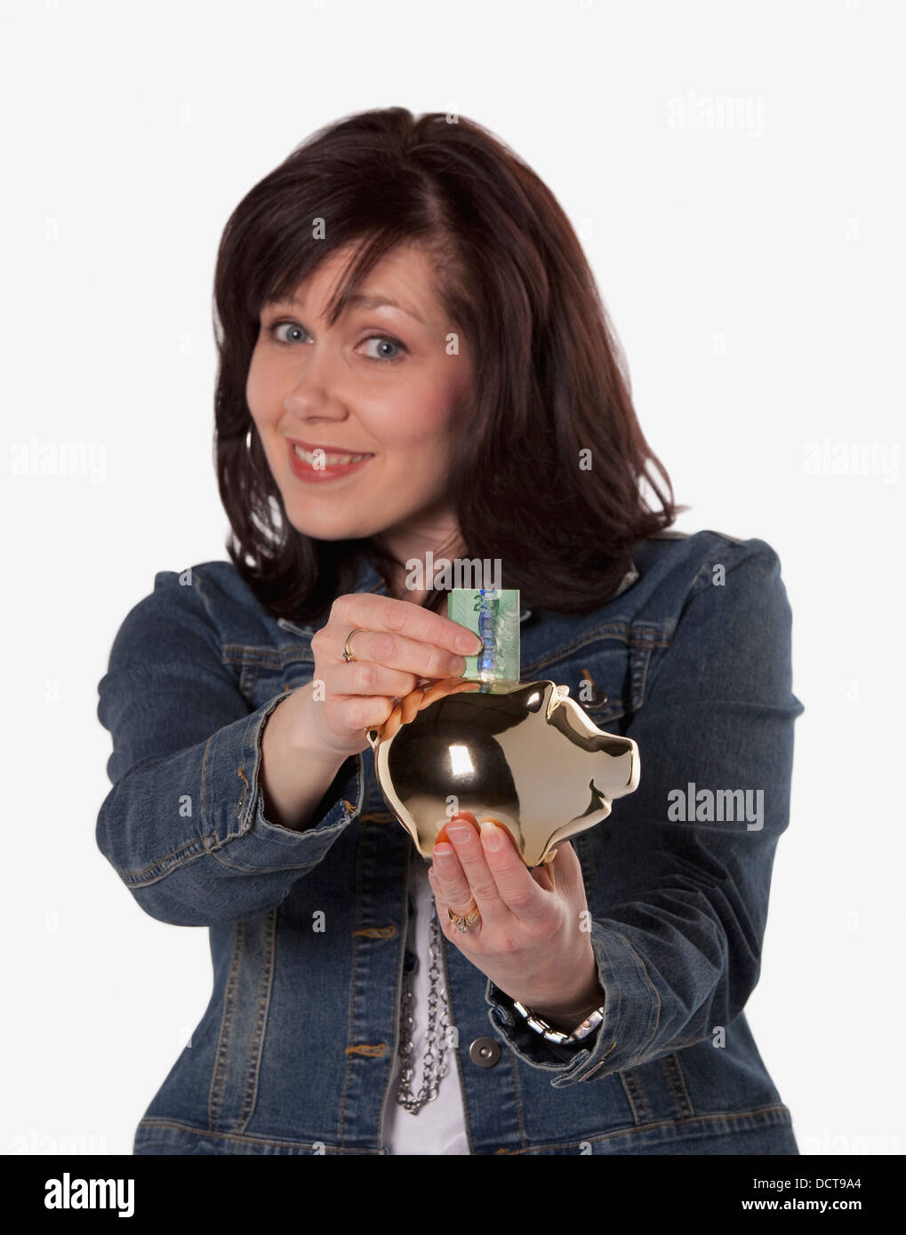 Donna di Risparmio di denaro in un salvadanaio; Edmonton, Alberta, Canada Foto Stock