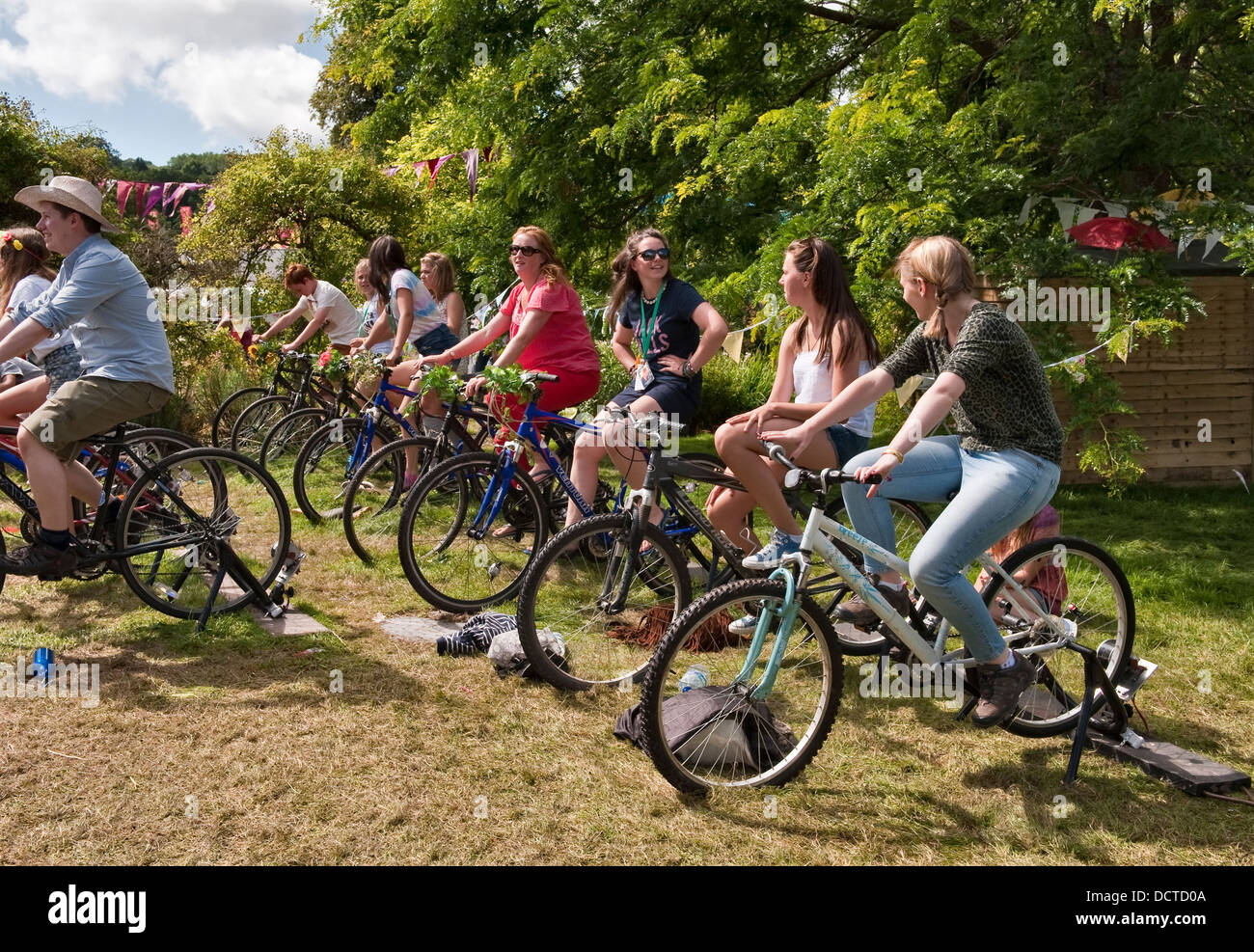 I festaioli usano generatori alimentati a bicicletta per ricaricare i telefoni cellulari al festival musicale annuale Green Man, Glanusk, Crickhowell, Galles, Regno Unito Foto Stock