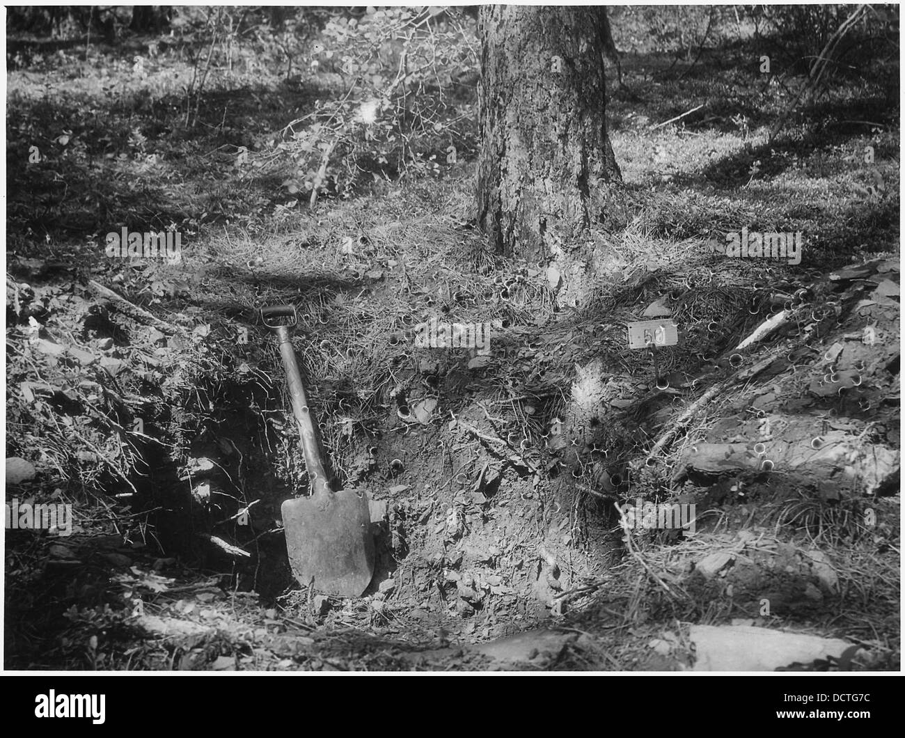 Questa fotografia mostra il pozzo di scoperta dell'Hardluck Lode, con una pala appoggiata al suo lato più profondo. Il pozzo faceva parte di un'operazione mineraria, segnando il sito di esplorazione mineraria. Foto Stock