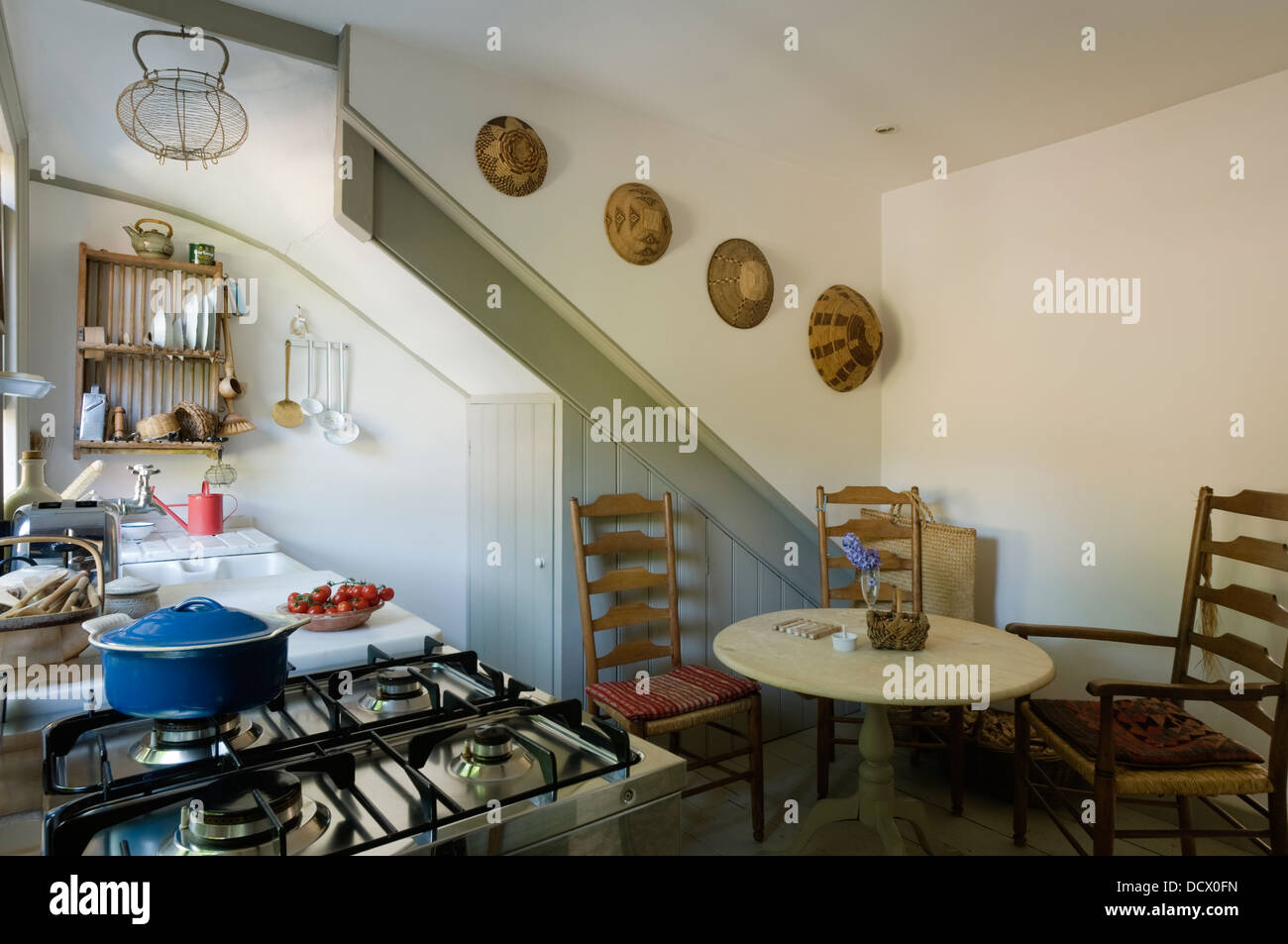 Sedie Ladderback e ripostigli in cucina con piastra e il rack di raccolta delle bocce africana Foto Stock