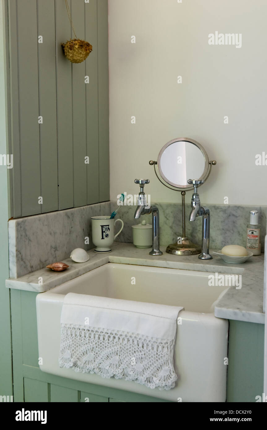 In vecchio stile lavandino e rubinetti in bagno pannellati con con ripiano in marmo lavello Foto Stock