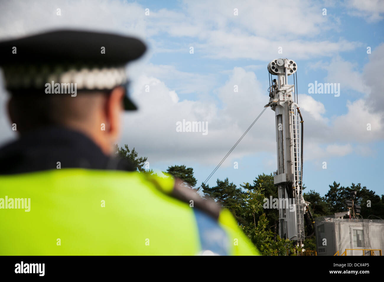 Un funzionario di polizia sta di guardia su una foratura fracking sito gestito dalla società la Cuadrilla in Balcombe. Foto Stock