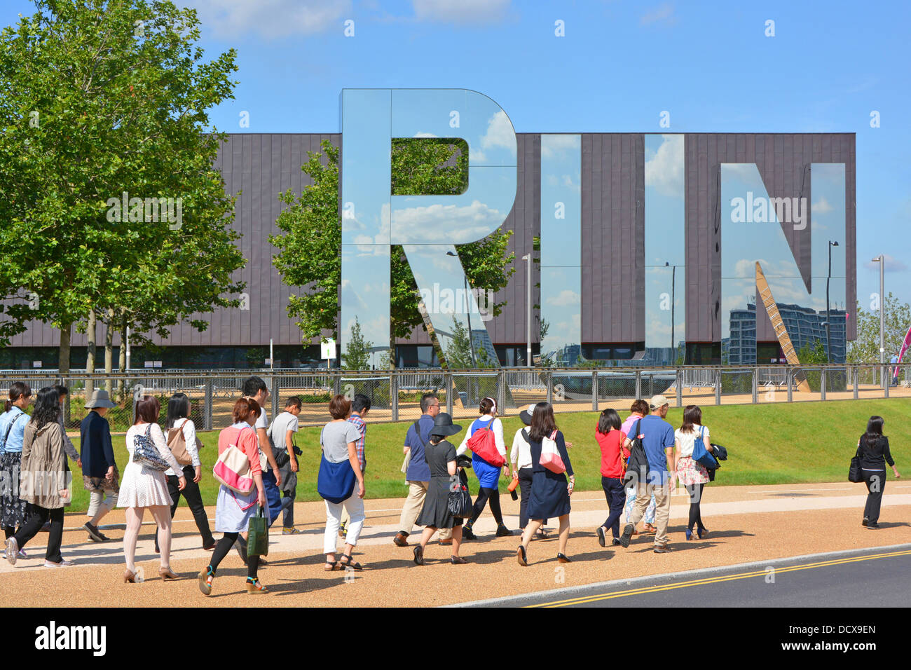 I turisti passeggiando accanto alla sede multisport al coperto Copper Box riaperta nel Queen Elizabeth Olympic Park Hackney Wick East London England UK Foto Stock