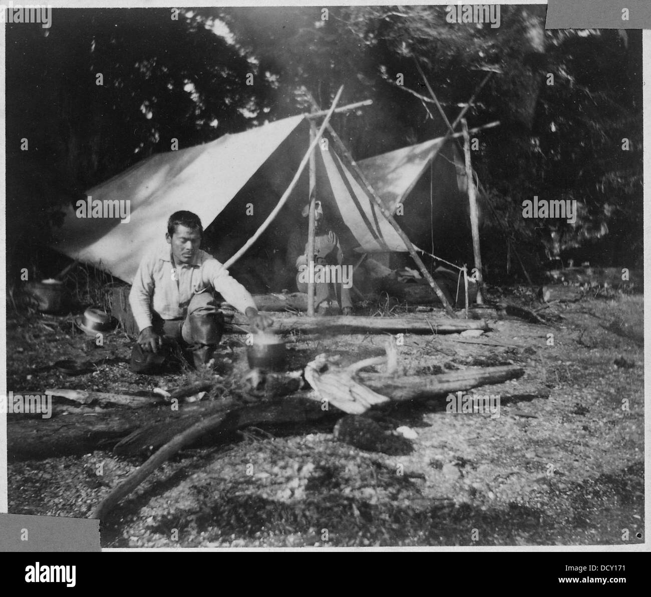 Questa fotografia raffigura individui nativi americani in un campo, che riflettono il loro stile di vita e le loro pratiche culturali in un contesto storico. Foto Stock
