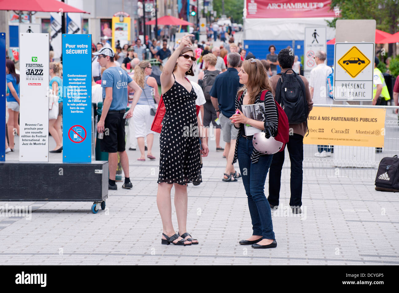 Conversazione tra due donne su Ste Catherine Street durante il Jazz Festival di Montreal. Foto Stock