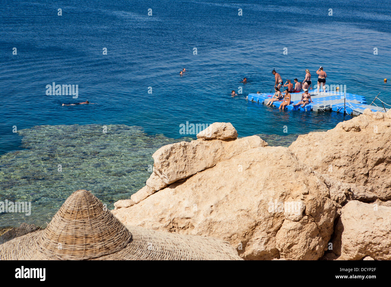 La gente di nuoto off di un pontile galleggiante nel Mar Rosso in Egitto Foto Stock