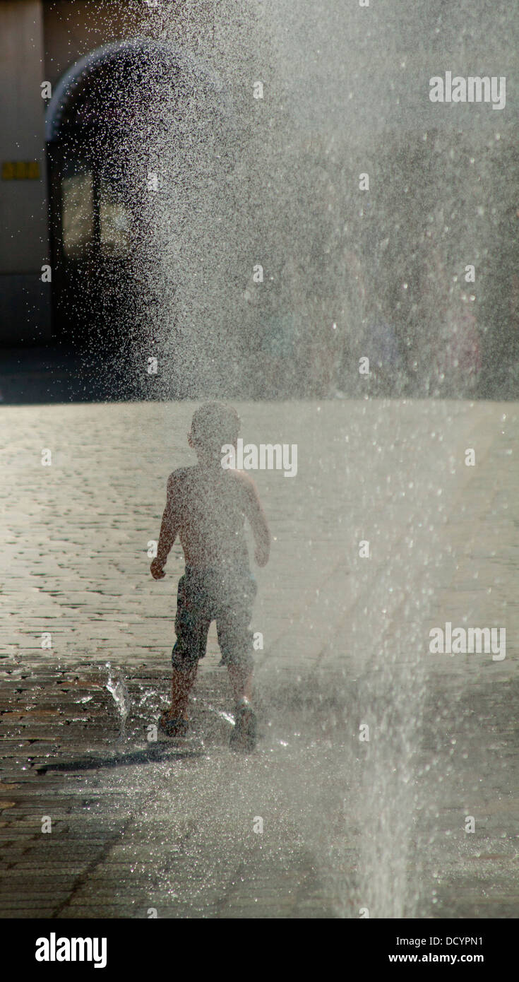 Uno spruzzo di acqua nel centro della città durante le calde giornate estive Foto Stock