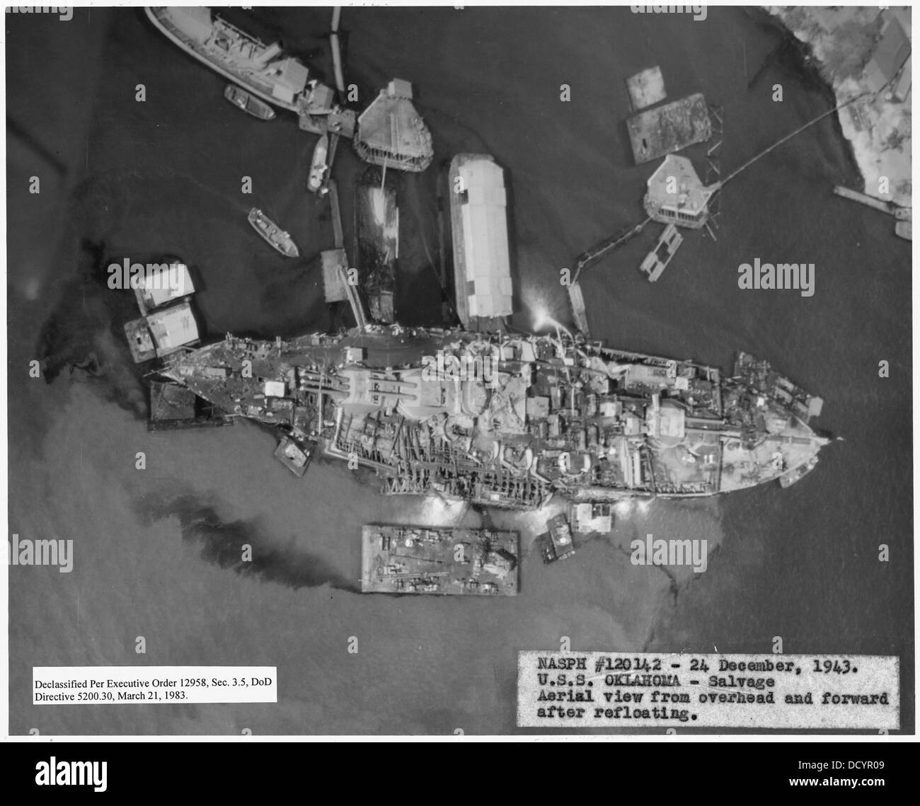Questa fotografia aerea scattata il 24 dicembre 1943 mostra la USS Oklahoma dopo essere stata rimessa in circolazione a seguito dell'attacco a Pearl Harbor. L'immagine fornisce una vista dall'alto e in avanti della nave durante le operazioni di salvataggio. Foto Stock