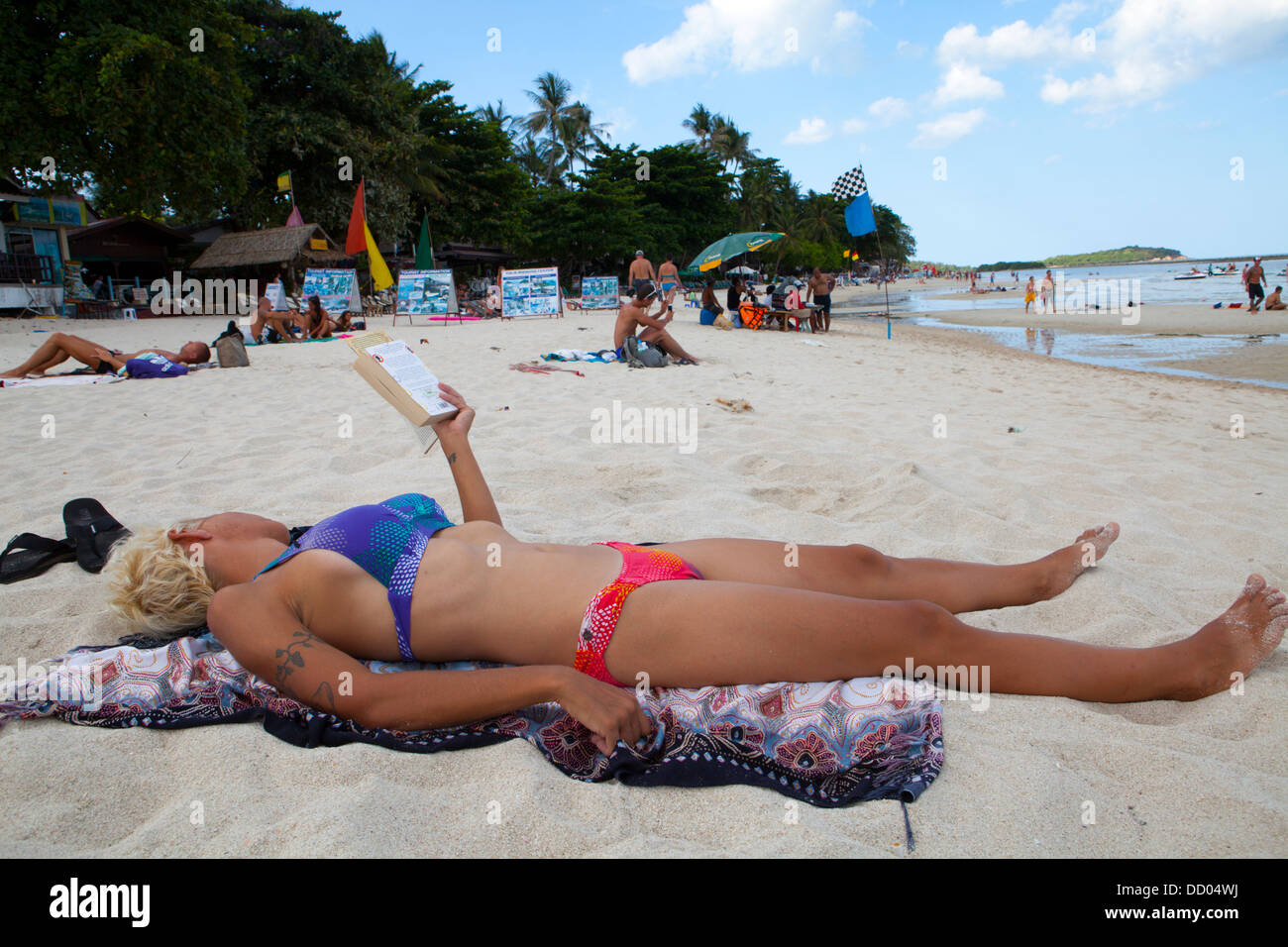 Una donna sunbathes Hat spiaggia di Chaweng a Ko Samui Island nel Golfo di Thailandia. Foto Stock