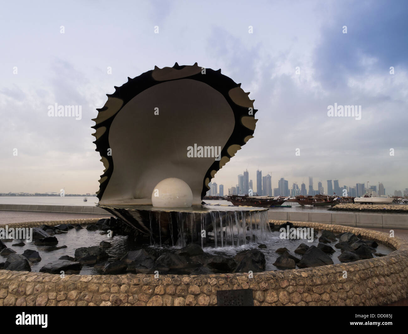 Close-up del gigante clam fontana con la skyline di Doha in background a Doha, in Qatar . Foto Stock