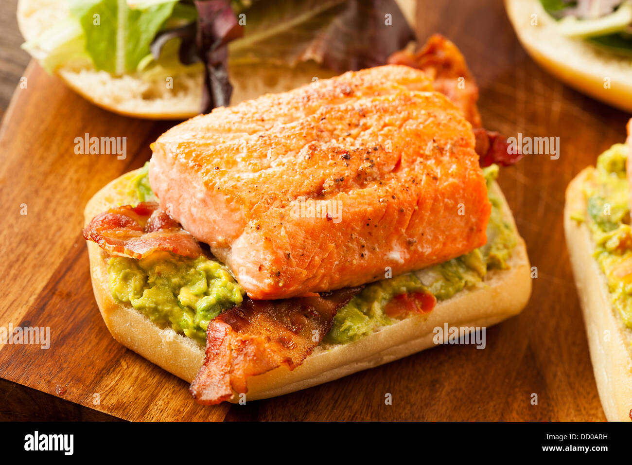 Salmone alla griglia con sandwich di pancetta e Guacamole su pane Foto Stock