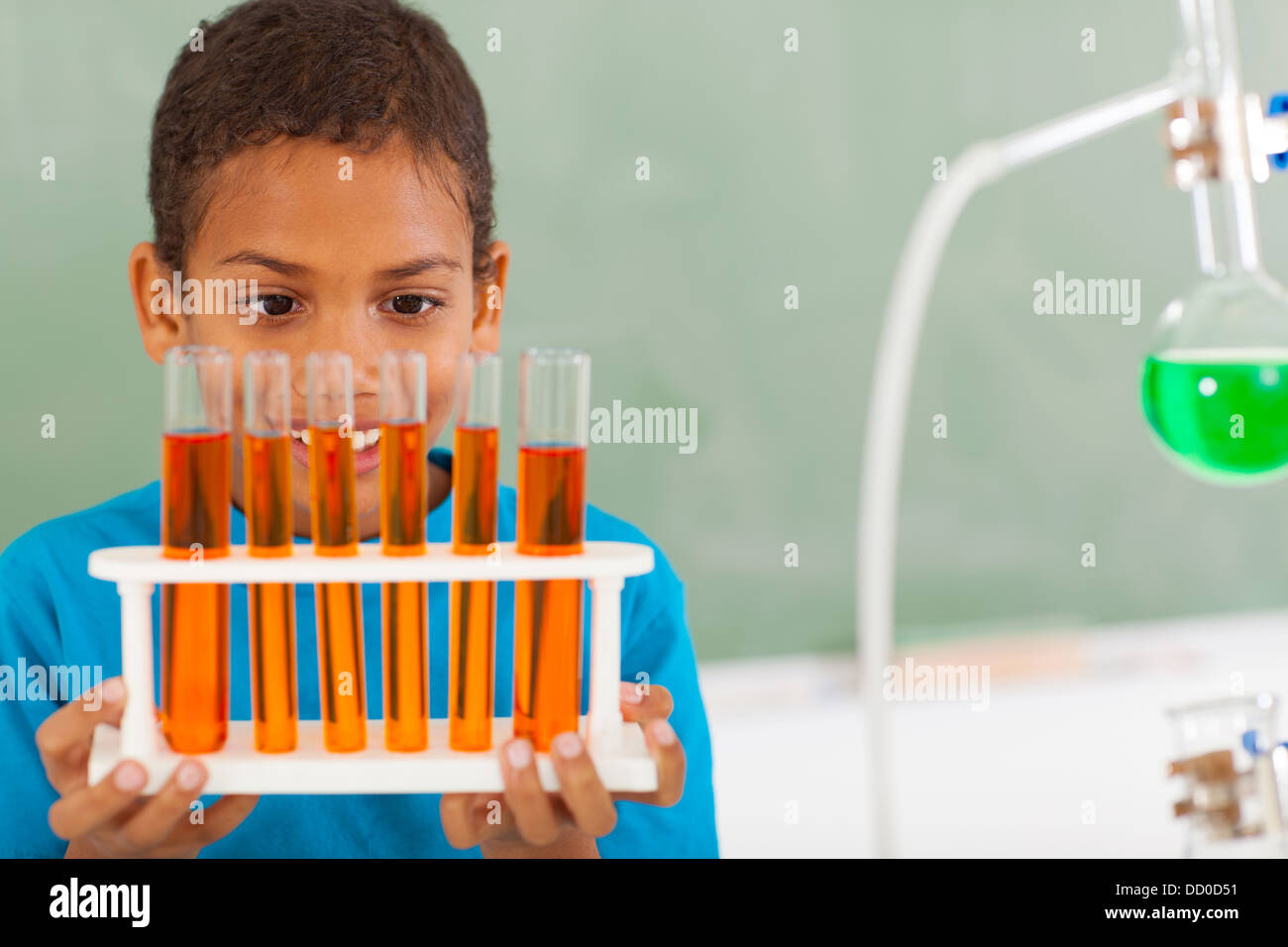 Carino maschio scuola primaria studente nella classe di scienze tubi di contenimento Foto Stock