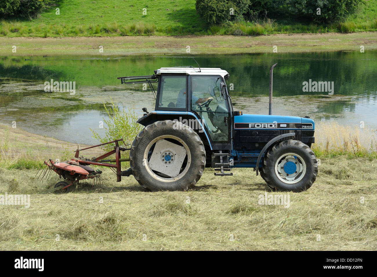 Un Pottinger Kombi 401 Voltafieno lavorando sulla parte posteriore di un trattore agricolo England Regno Unito Foto Stock